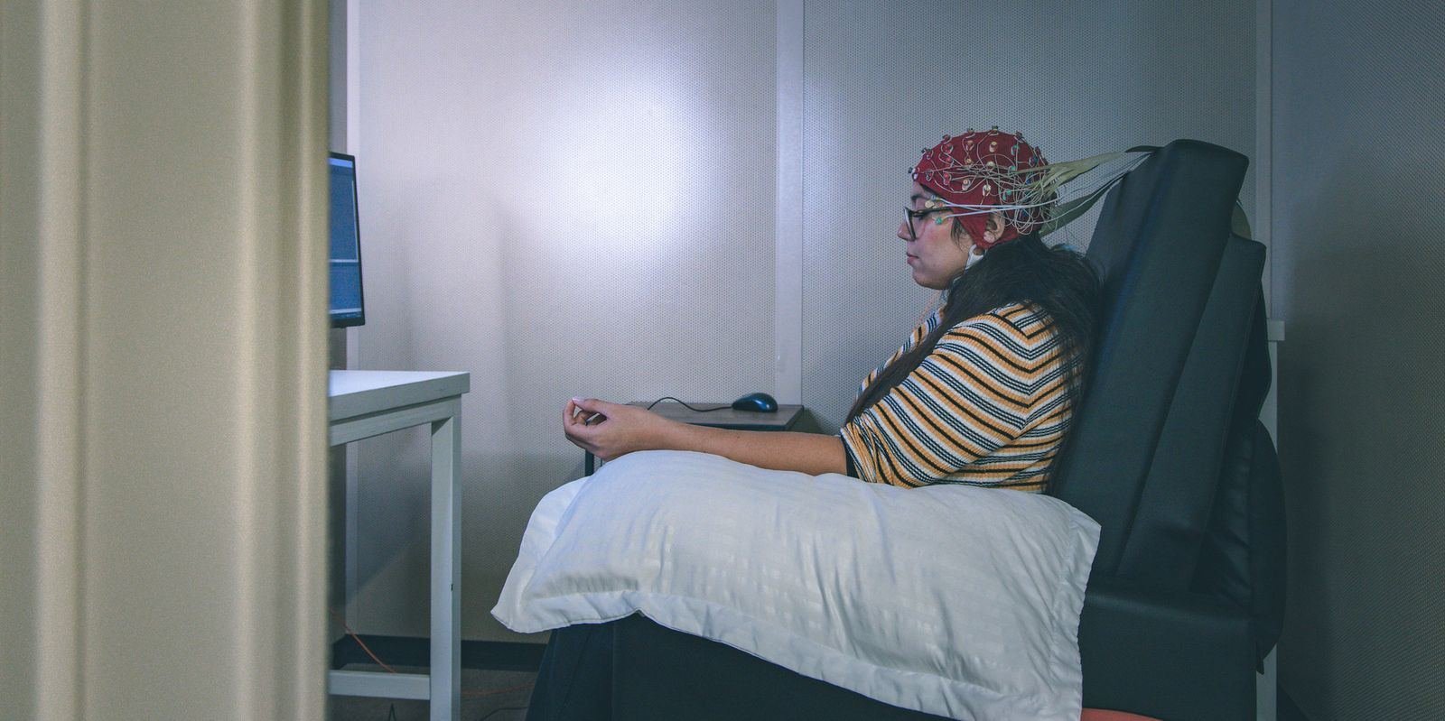 Researcher wearing an EEG cap in an AC3E laboratory
