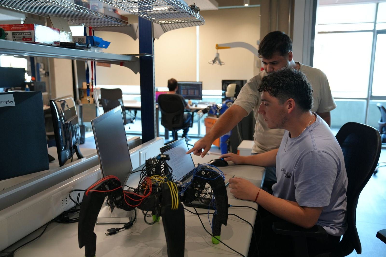 Researchers working on a robotics prototype in an AC3E laboratory