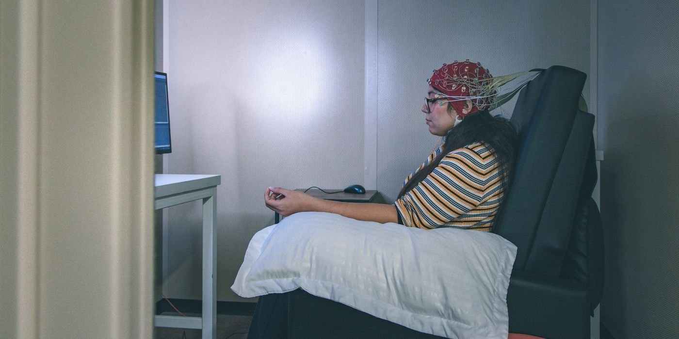 Researcher wearing an EEG cap in an AC3E laboratory